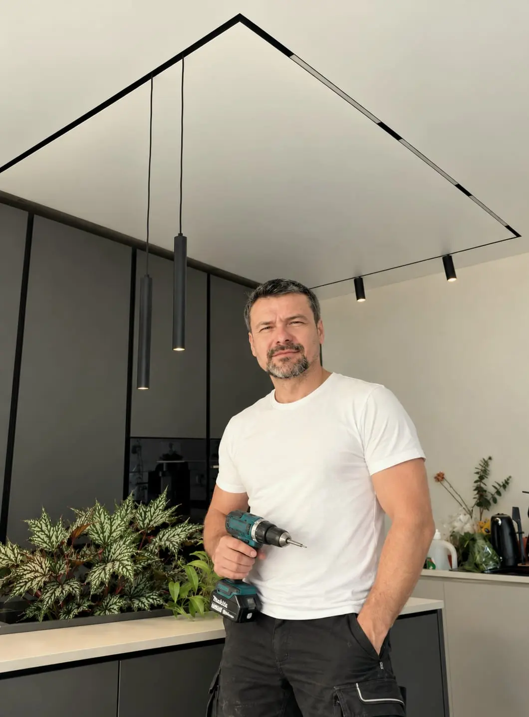 Roman Kronewald in einer Küche mit Spanndecke und Magnetschienen-System